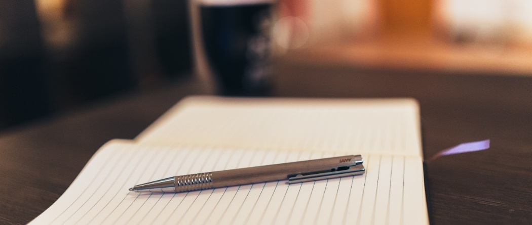 a writing pen laying on a notebook