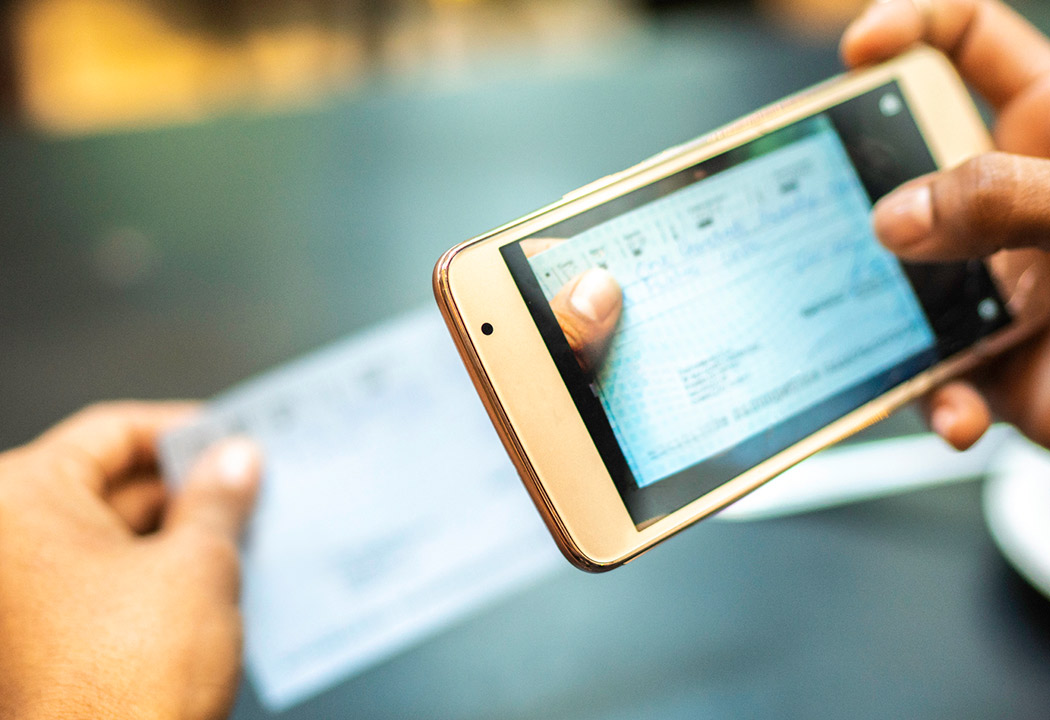 Person depositing a check with their online banking app and phone.