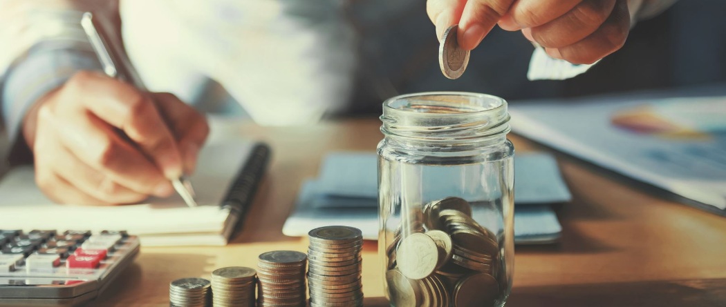 a person putting coins in a jar